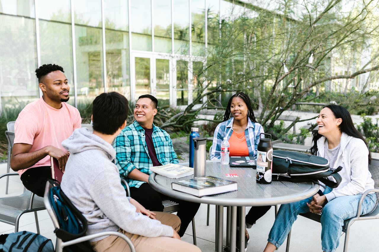 services-03 University students studying together outside at a campus table.
